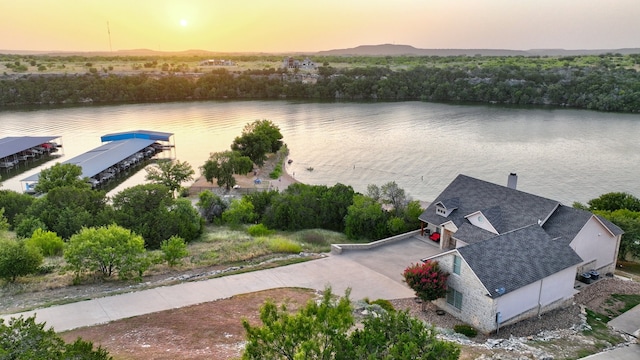 aerial view at dusk featuring a water view