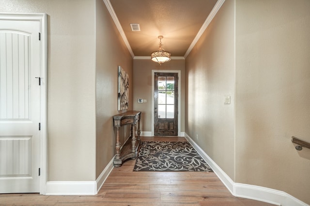 doorway featuring crown molding and light wood-type flooring