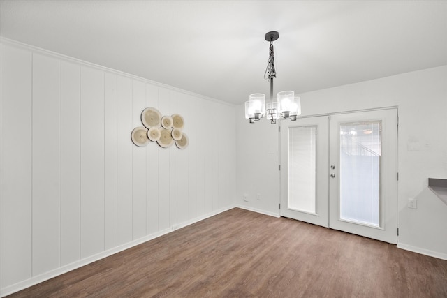 spare room with french doors, hardwood / wood-style floors, and a chandelier