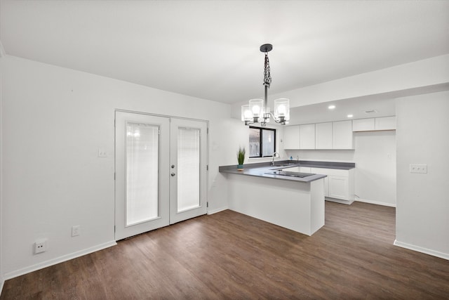 kitchen featuring white cabinetry, kitchen peninsula, french doors, hanging light fixtures, and sink