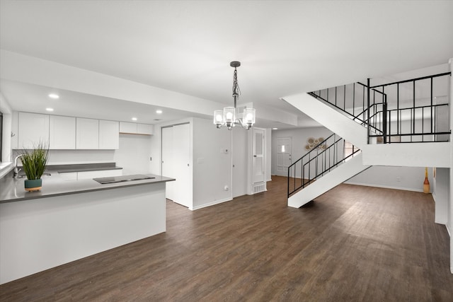 kitchen featuring an inviting chandelier, white cabinetry, hanging light fixtures, dark hardwood / wood-style flooring, and black electric cooktop