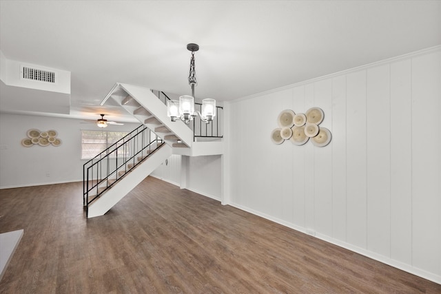 interior space with ceiling fan with notable chandelier, dark hardwood / wood-style flooring, and crown molding