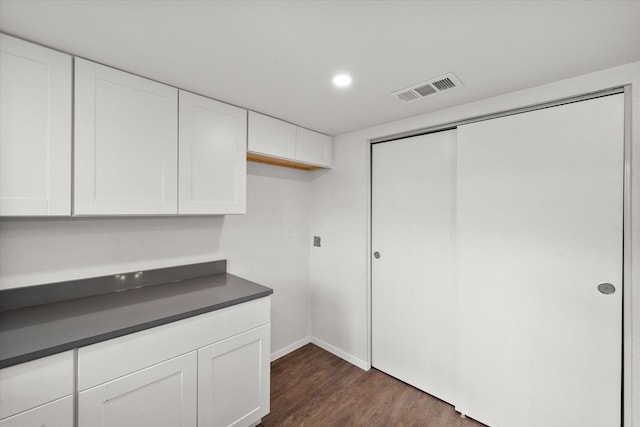 kitchen featuring dark wood-type flooring and white cabinetry