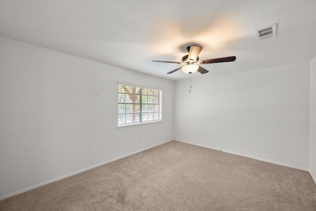 empty room featuring ceiling fan and carpet