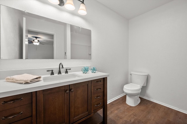 bathroom featuring toilet, vanity, ceiling fan, and hardwood / wood-style flooring