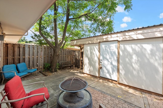 view of patio / terrace with an outdoor living space with a fire pit and a storage unit