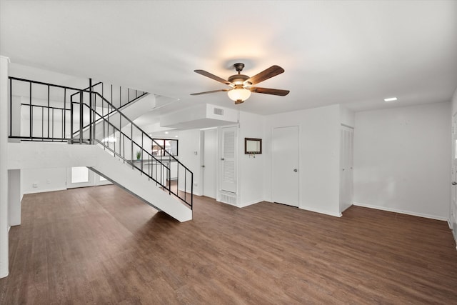 unfurnished living room featuring ceiling fan and dark wood-type flooring