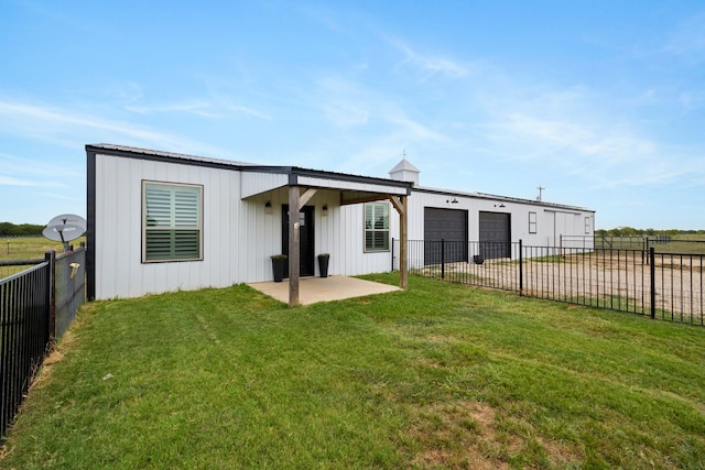 back of house with a garage, fence, a yard, driveway, and a patio area