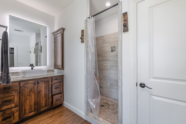 bathroom with hardwood / wood-style floors, a shower with curtain, and vanity