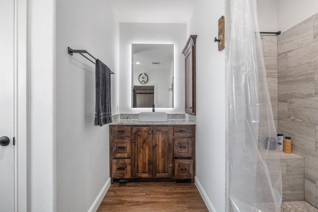 bathroom with curtained shower, hardwood / wood-style floors, and vanity