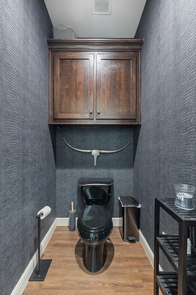 interior space featuring toilet and hardwood / wood-style flooring