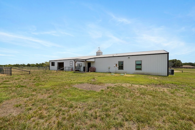 rear view of property featuring a yard and an outdoor structure