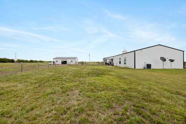 view of yard with a rural view, cooling unit, and an outdoor structure