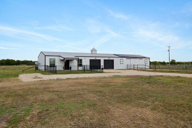 exterior space with a front yard, solar panels, and a garage