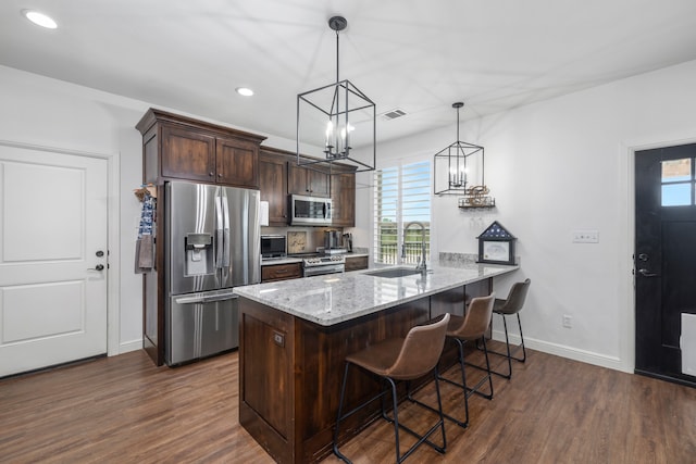 kitchen with kitchen peninsula, appliances with stainless steel finishes, a wealth of natural light, and sink