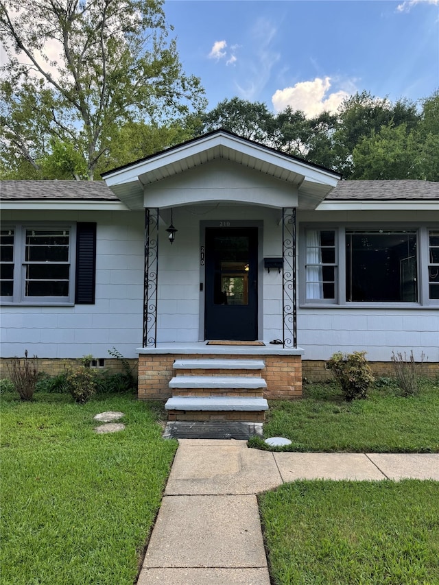 property entrance featuring a porch and a lawn