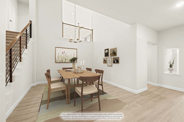 dining area with light wood-type flooring and a notable chandelier