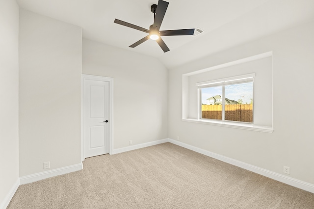 carpeted spare room featuring ceiling fan and lofted ceiling