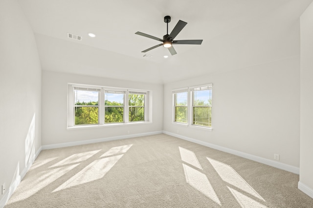 empty room featuring ceiling fan, lofted ceiling, and light carpet