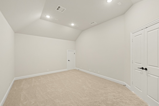 carpeted empty room with lofted ceiling