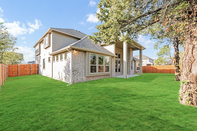 back of property with a yard and a patio