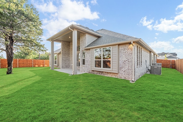 back of house featuring a yard and cooling unit