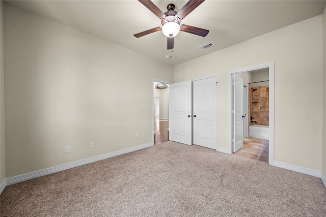 unfurnished bedroom featuring light carpet, ceiling fan, and connected bathroom