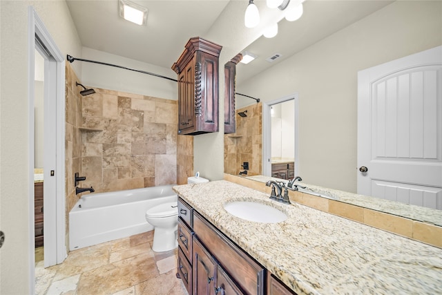 full bathroom with tile patterned floors, vanity, tiled shower / bath, and toilet