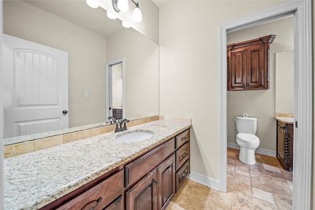 bathroom featuring tile patterned flooring, toilet, and vanity