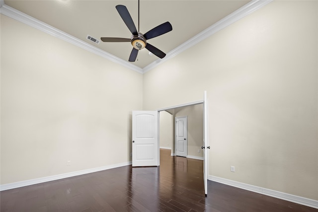 unfurnished bedroom featuring a towering ceiling, ceiling fan, dark hardwood / wood-style floors, and crown molding