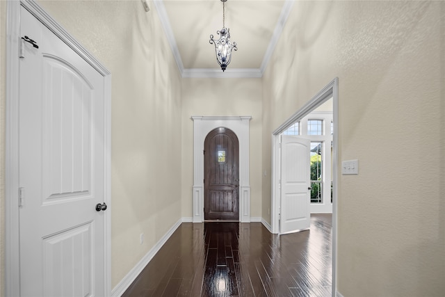 entryway featuring ornamental molding, dark hardwood / wood-style flooring, and a chandelier