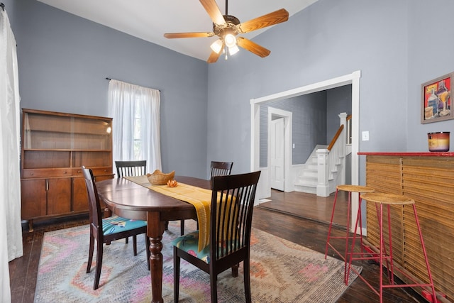 dining area featuring ceiling fan, stairway, and wood finished floors