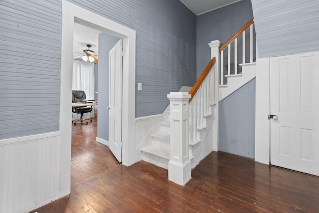 stairway with wood-type flooring and ceiling fan