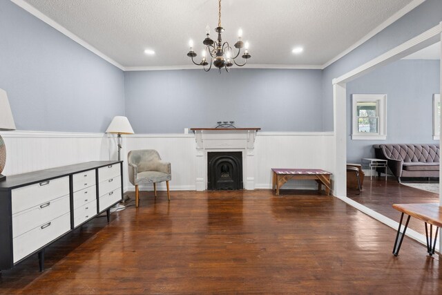 sitting room featuring wood-type flooring, a textured ceiling, a chandelier, and ornamental molding