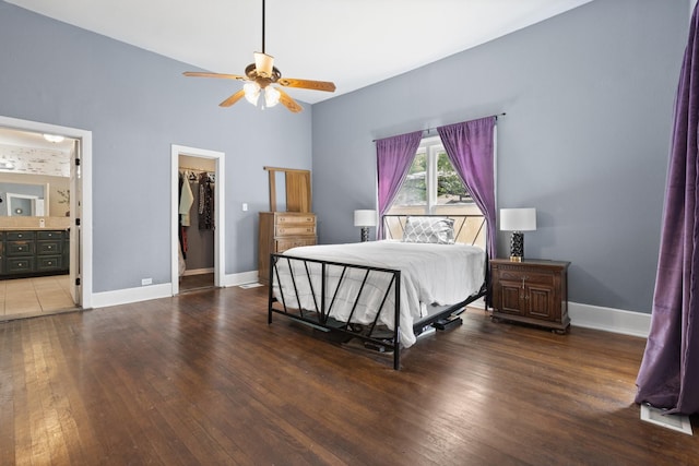 bedroom with baseboards, a walk in closet, and hardwood / wood-style floors