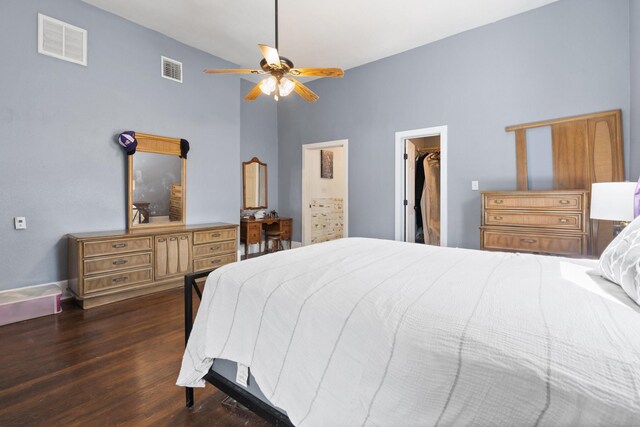 bedroom with ceiling fan, dark wood-type flooring, a spacious closet, a high ceiling, and a closet