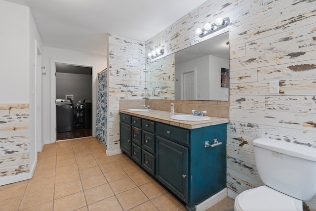 bathroom featuring toilet, tile walls, double sink vanity, backsplash, and tile patterned floors