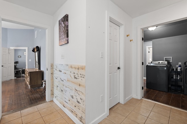 hallway featuring washing machine and dryer and light tile patterned flooring