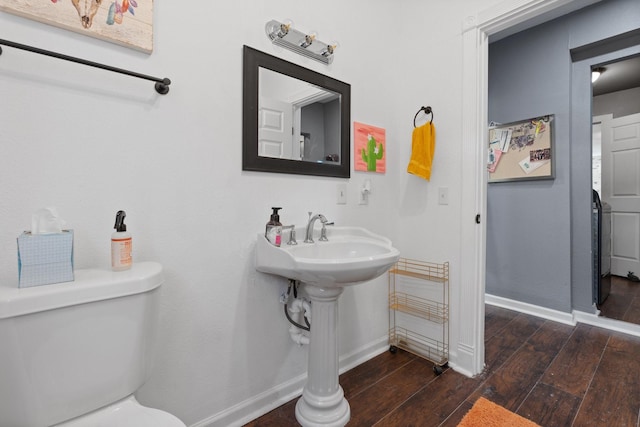 bathroom with wood-type flooring, toilet, and baseboards