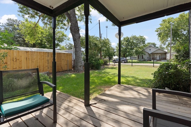 wooden terrace featuring a lawn and fence