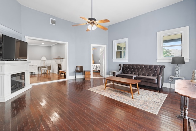 living room featuring hardwood / wood-style floors, a towering ceiling, and ceiling fan