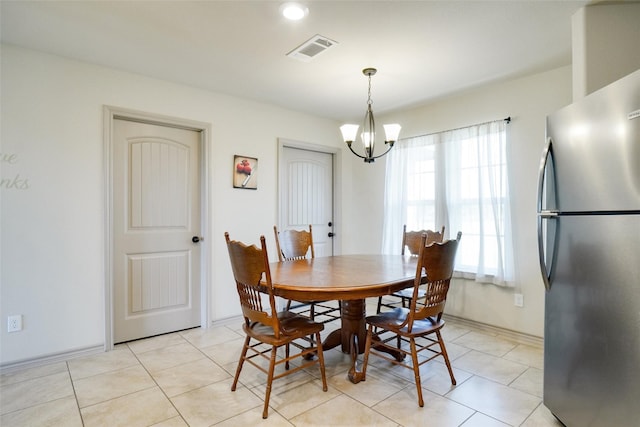 tiled dining room featuring a notable chandelier