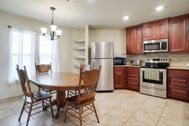 kitchen featuring stainless steel appliances, backsplash, a chandelier, decorative light fixtures, and light tile patterned floors