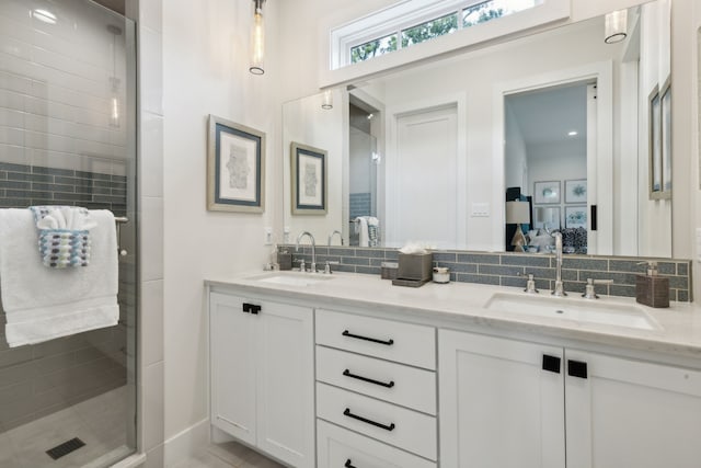 bathroom with an enclosed shower, tasteful backsplash, and double sink vanity