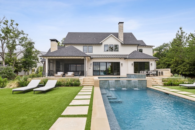 rear view of property with a yard, pool water feature, and a patio area