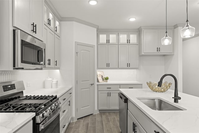 kitchen featuring white cabinets, stainless steel appliances, sink, and decorative light fixtures