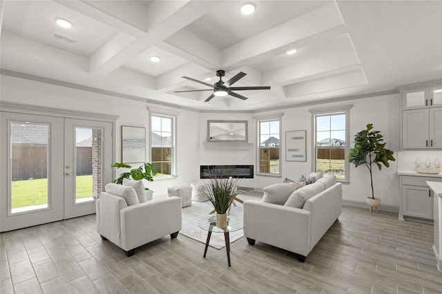 living room with light wood-type flooring, beamed ceiling, coffered ceiling, and ceiling fan