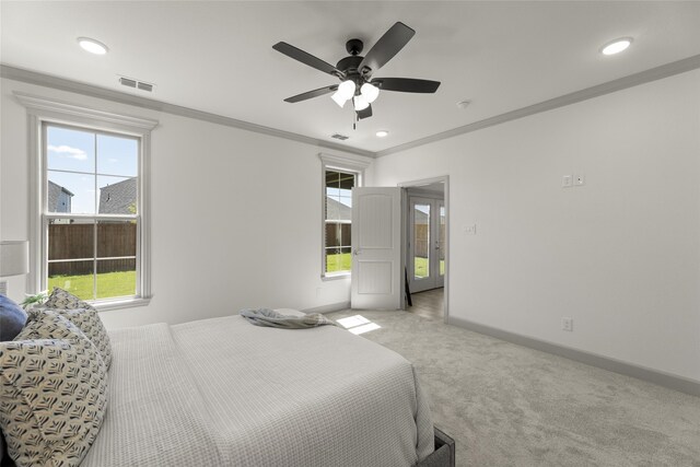 carpeted bedroom with multiple windows, ornamental molding, and ceiling fan