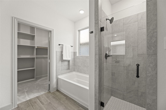 bathroom featuring shower with separate bathtub