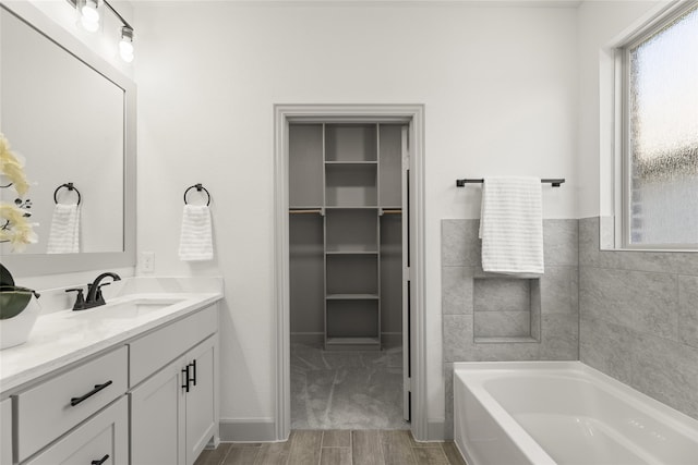 bathroom featuring vanity, a washtub, and hardwood / wood-style floors